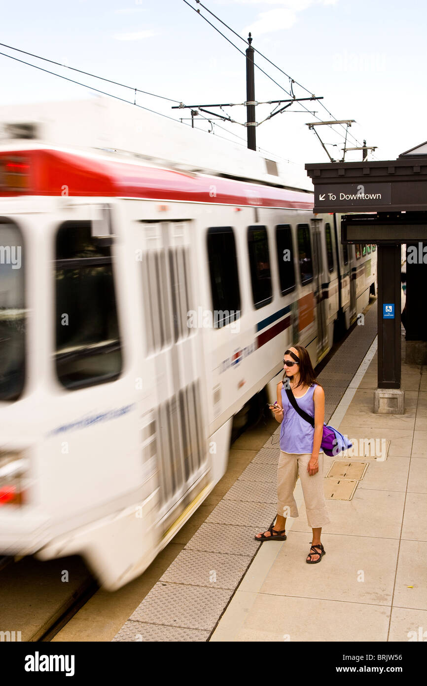 Una giovane donna ascolta il suo lettore MP3 mentre è in attesa per il suo treno di Salt Lake City, Utah. Foto Stock