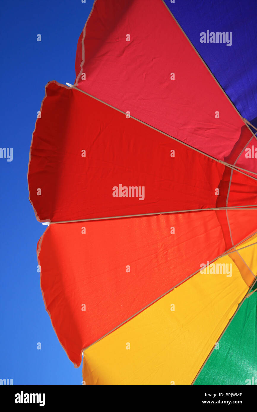 Parte di un arcobaleno ombrellone con cielo blu sullo sfondo Foto Stock