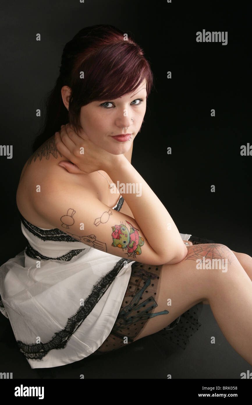Giovane donna con tatuato spider web sul ginocchio Foto Stock