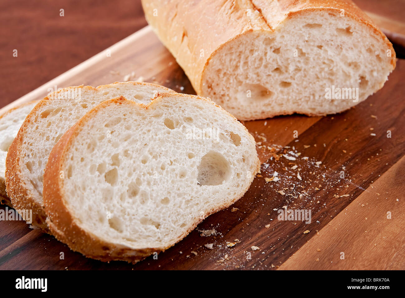 Filone di spesse fette di pane italiano su un tagliere. closeup formato orizzontale. Foto Stock