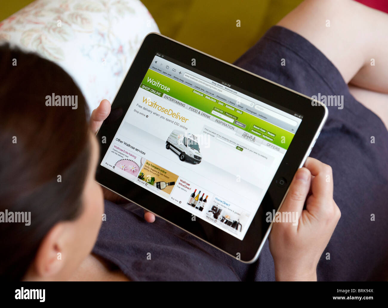 Donna shopping presso home online tramite wifi a Waitrose shop su un computer tablet iPad Foto Stock