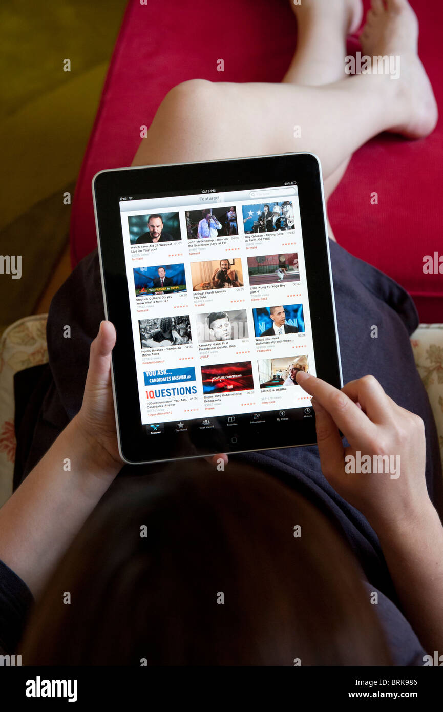 Navigazione donna Youtube la condivisione video sito usando il wifi su un computer tablet iPad Foto Stock