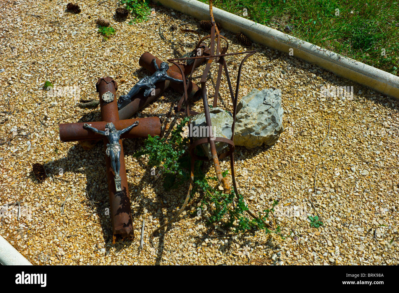 Rusty crocifissi su un sentiero di ghiaia in un cimitero francese Foto Stock