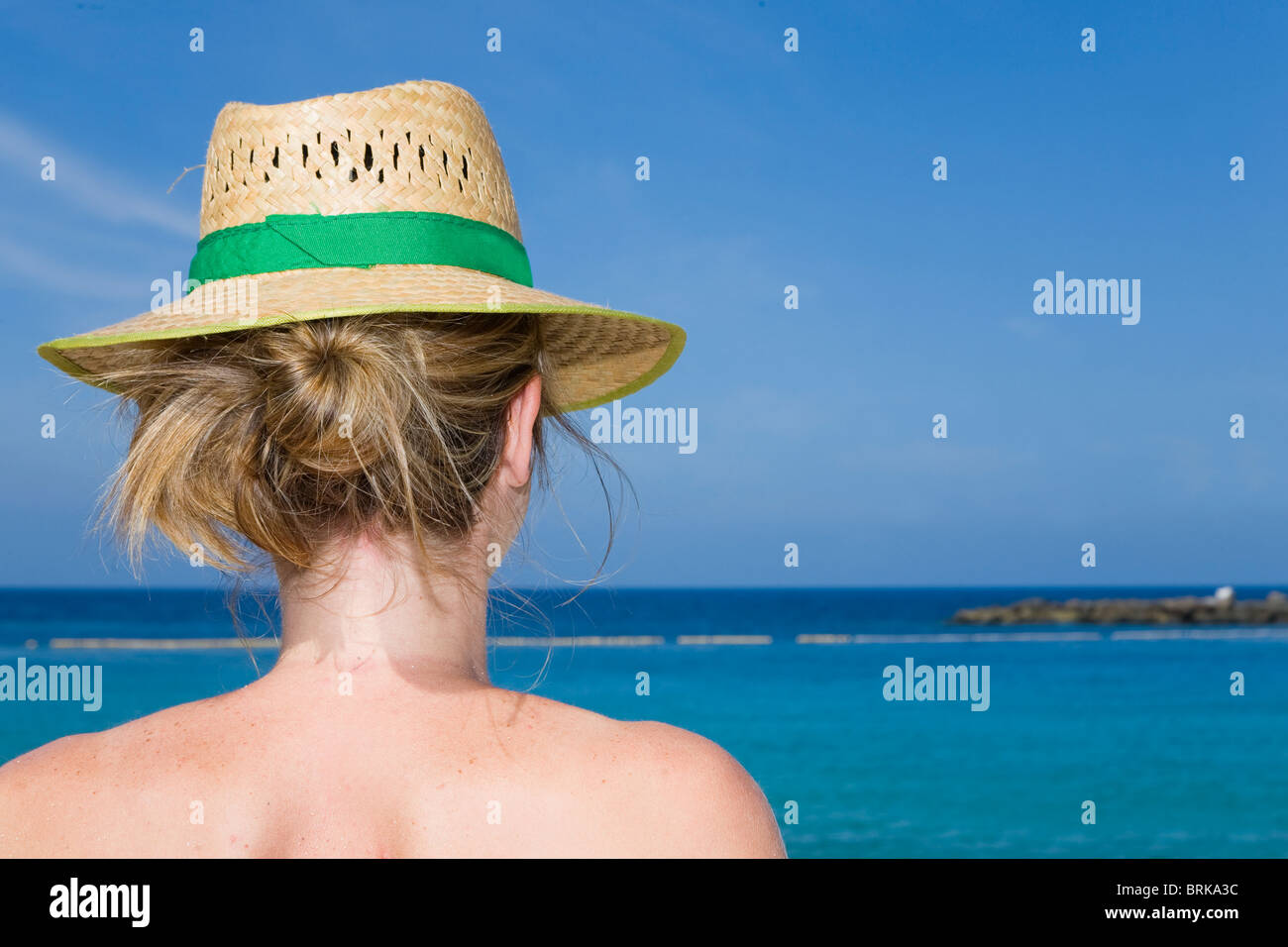 La donna nel cappello di paglia a guardare il mare in una giornata di sole  Foto stock - Alamy