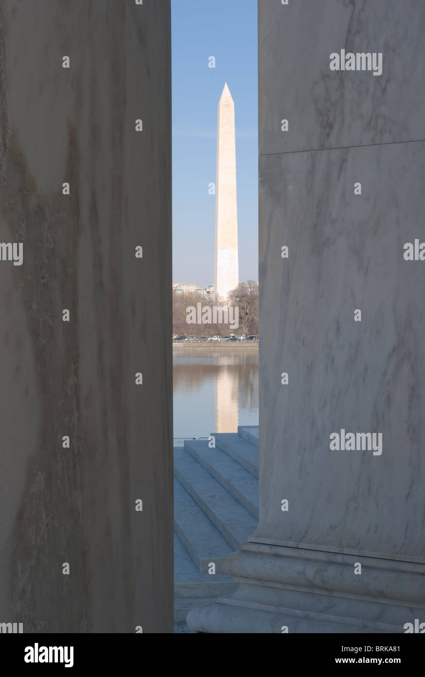 Il Monumento di Washington visto attraverso le colonne del Jefferson Memorial contro un cielo blu e la luce del pomeriggio Foto Stock