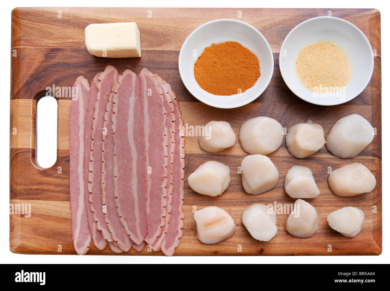 Mise en place ingredienti per rendere pancetta avvolto capesante stabiliti ordinatamente su un tagliere prima della cottura Foto Stock