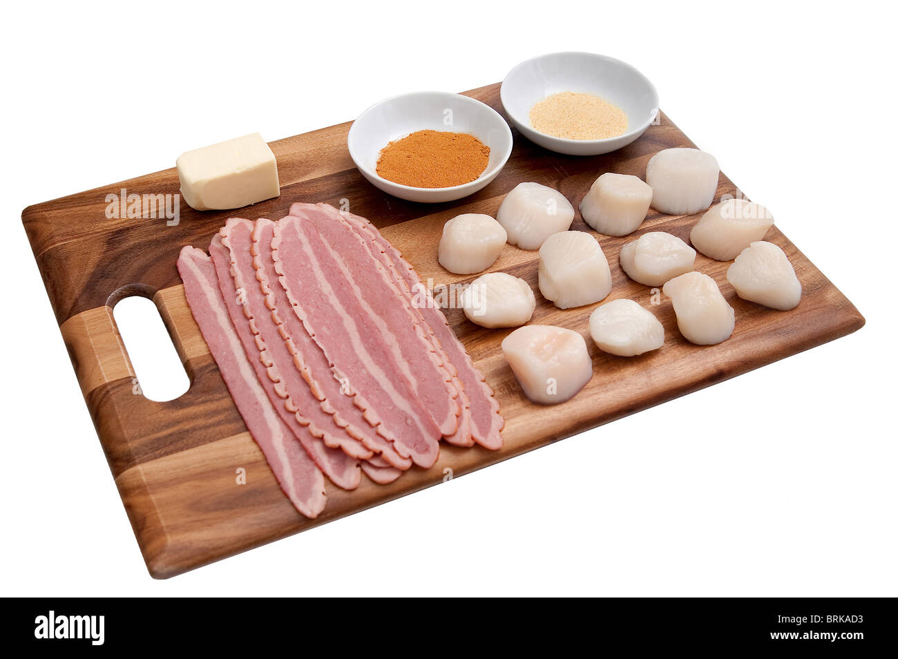 Mise en place ingredienti per rendere pancetta avvolto capesante stabiliti ordinatamente su un tagliere prima della cottura Foto Stock