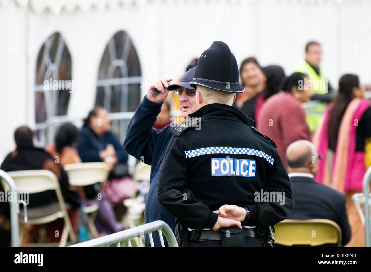 Un funzionario di polizia a parlare con un membro del pubblico al Ganesh Festival in Shoeburyness in Essex. Foto Stock