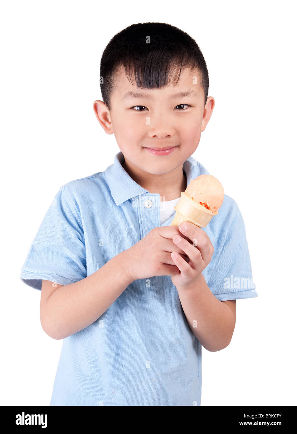 Una felice ragazzo asiatico di mangiare il sorbetto all'arancia isolato su bianco Foto Stock