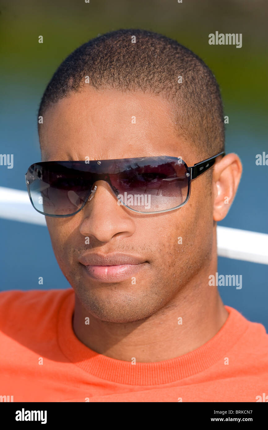 Un giovane attraente African American uomo seduto dall'acqua Foto Stock