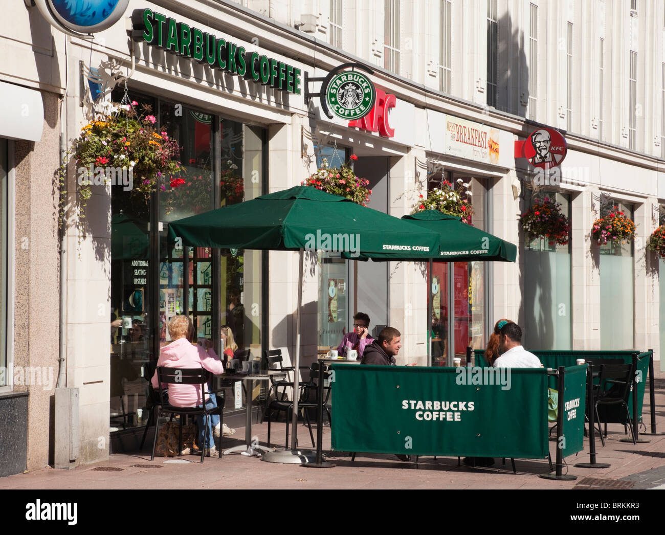 Caffetteria Starbucks Coffee shop con persone sedute a tavoli su posti a sedere esterni. Cardiff Caerdydd), Glamorgan, South Wales, Regno Unito. Foto Stock