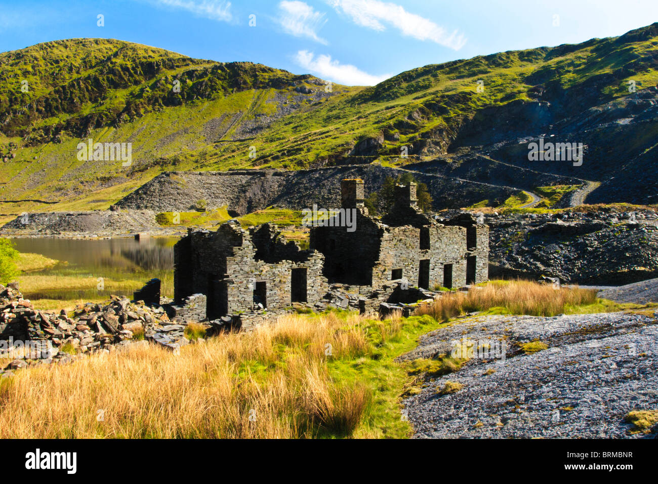 Abbandonata la Pietra e Ardesia case di minatori sulle rive di un lago sopra ffestiniog in Galles Foto Stock