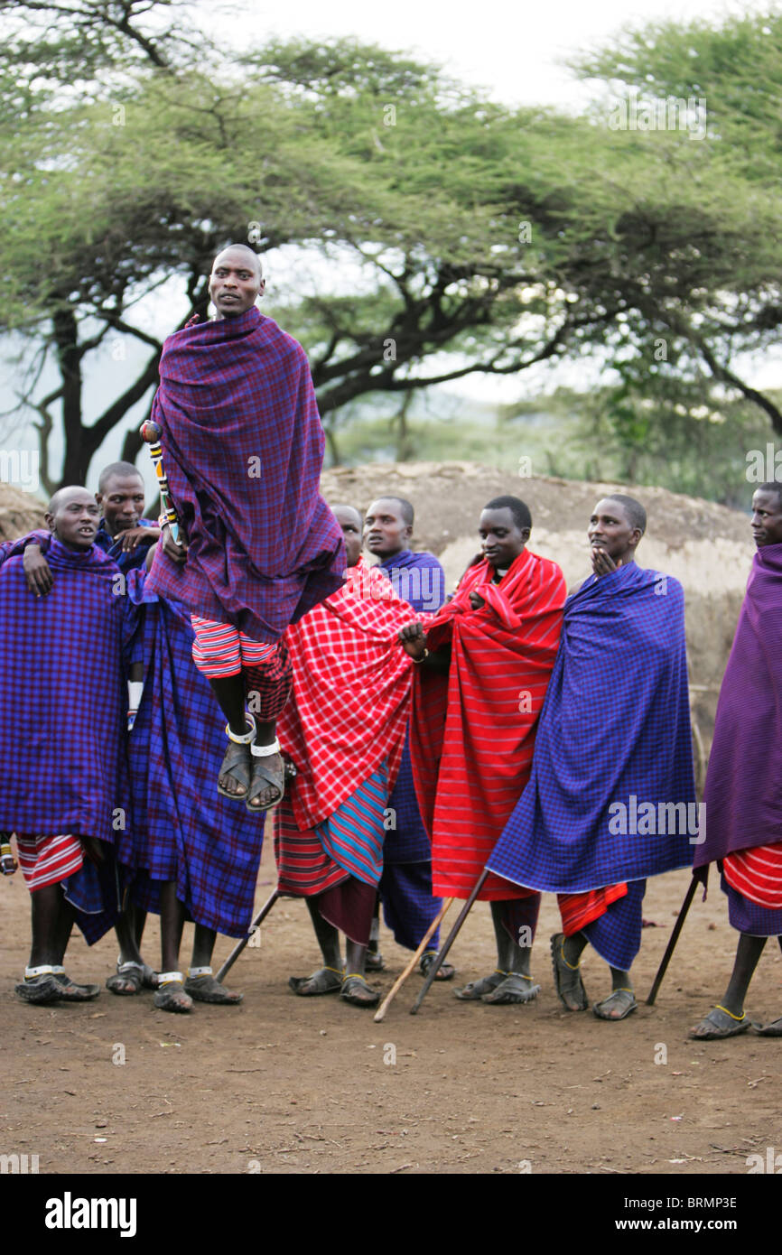 Maasai uomini che espongono la loro tradizionale danza di salto indossando shukas Foto Stock