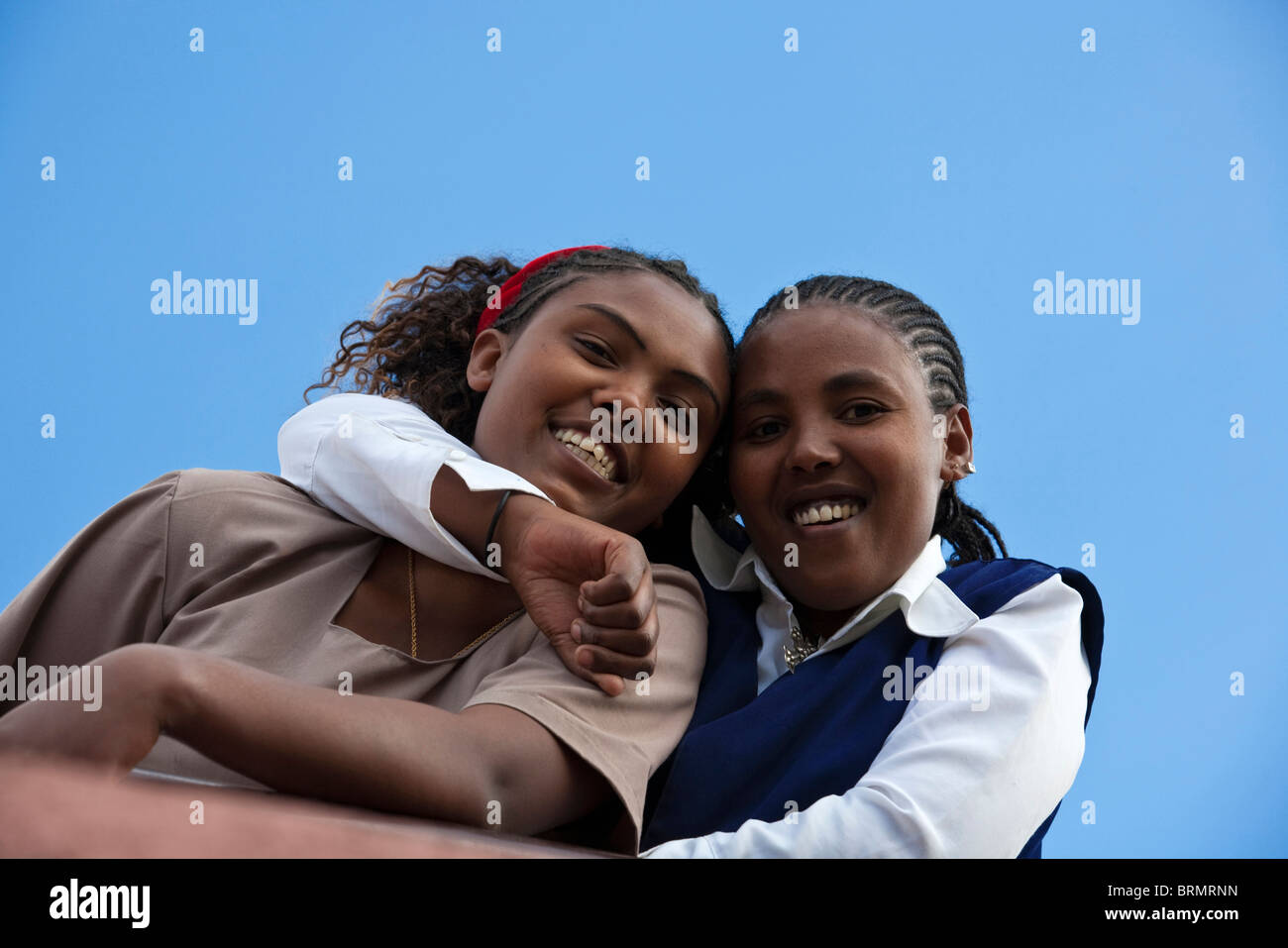 Due donne locali in abito occidentale sorridente e abbracciando ogni altro Foto Stock