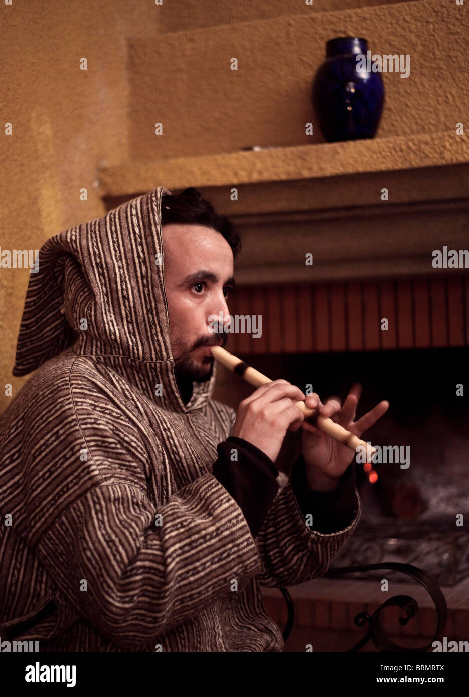 Un nomade berbero intrattiene gli ospiti dalla riproduzione di musica araba su un flauto di legno Foto Stock