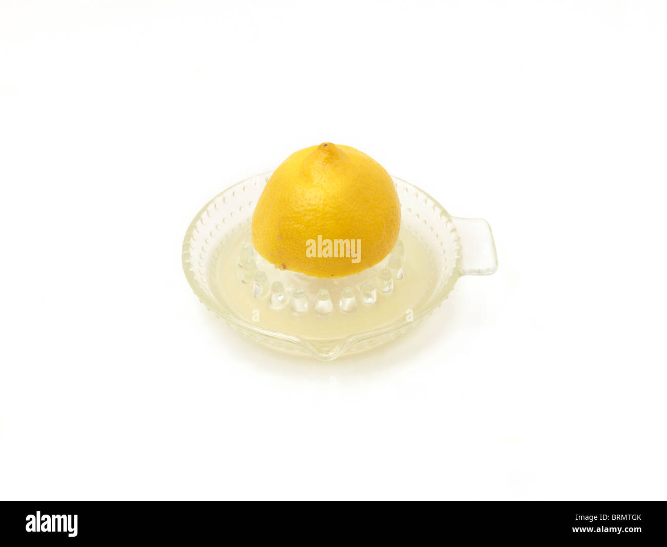 Succo di limone essendo spremuta di limone su vetro centrifuga Foto Stock