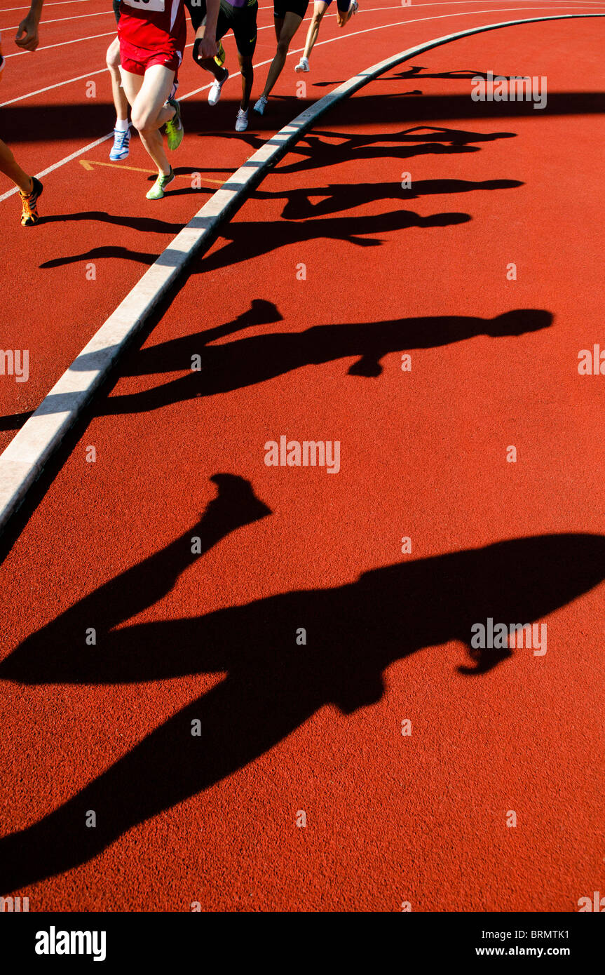 Le ombre dei corridori durante la 800m durante la gara su pista all'aperto e il campo della concorrenza Foto Stock