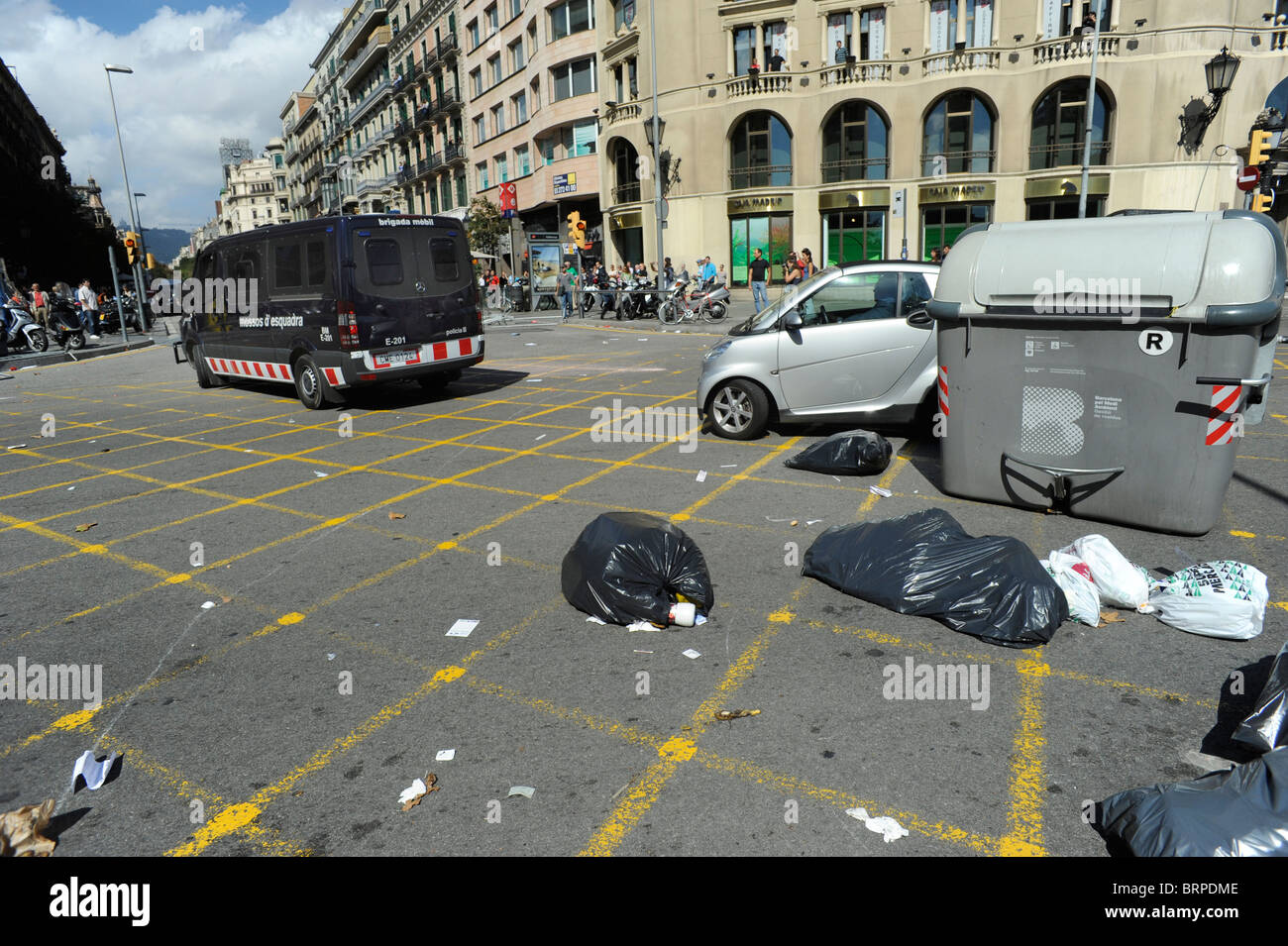 Un furgone di polizia irrompe attraverso una barriera di contenitori durante scontri nella città di Barcellona durante lo sciopero generale in Spagna. Foto Stock