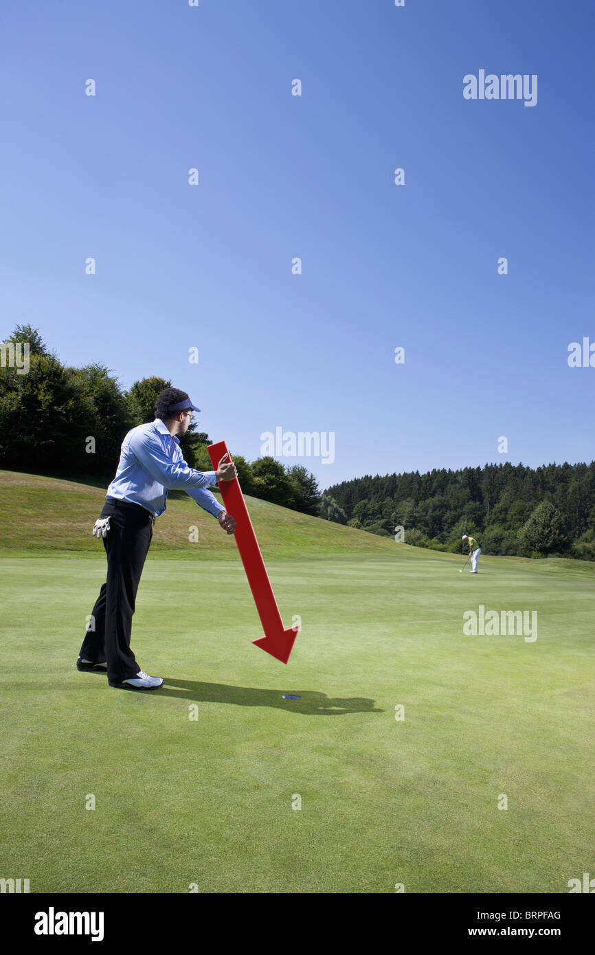 Caddy rivolto verso un foro sul campo da golf Foto Stock