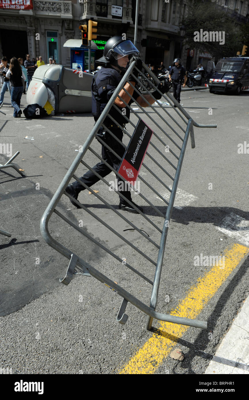 La polizia antisommossa rimuovendo gli ostacoli durante gli scontri nel centro della città di Barcellona durante lo sciopero generale del 29 settembre 2010. Foto Stock