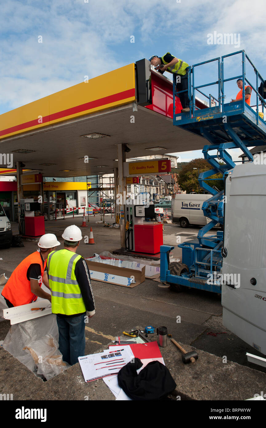 Operai il rinnovamento e il rebranding di un distributore di benzina Shell garage come Texaco , REGNO UNITO Foto Stock