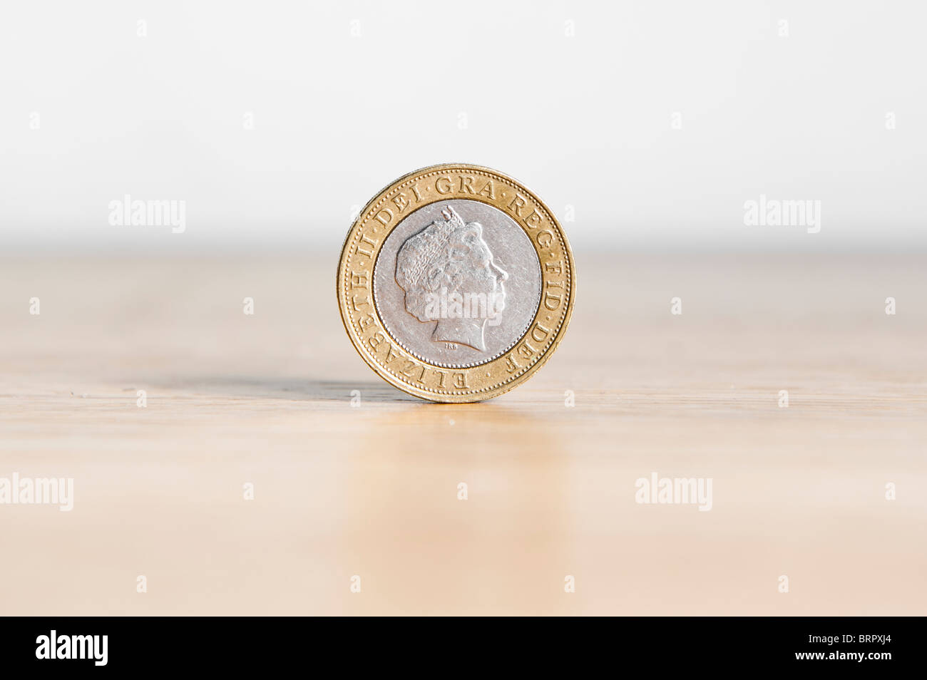 Due Pound coin isolato, in piedi sul bordo con ombra Foto Stock