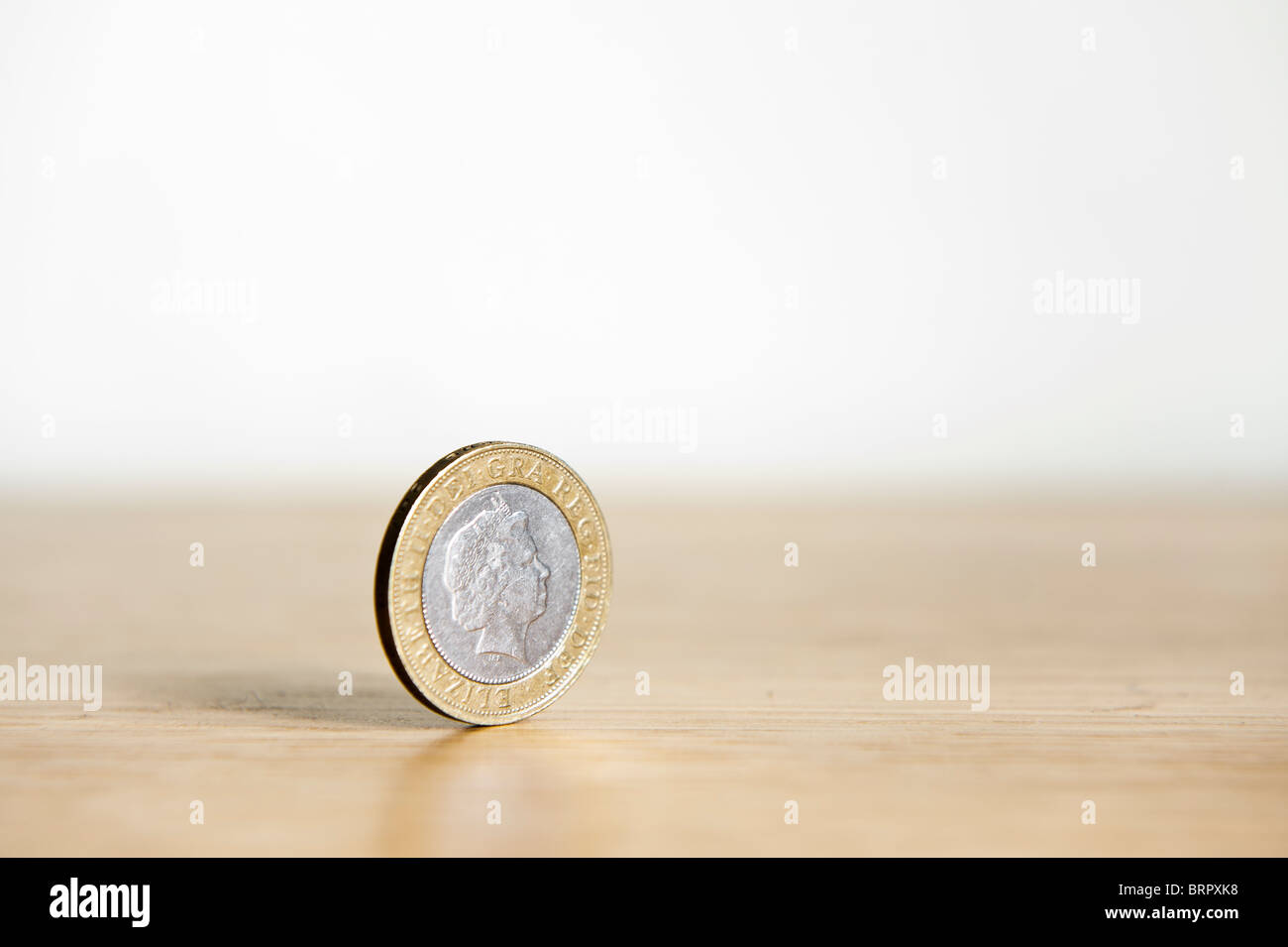 Due Pound coin isolato, in piedi sul bordo con ombra Foto Stock