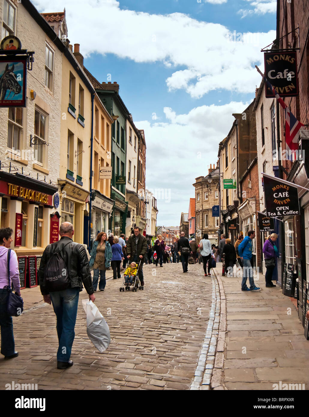 High street con persone shopping a Whitby high street, North Yorkshire, Inghilterra, Regno Unito Foto Stock