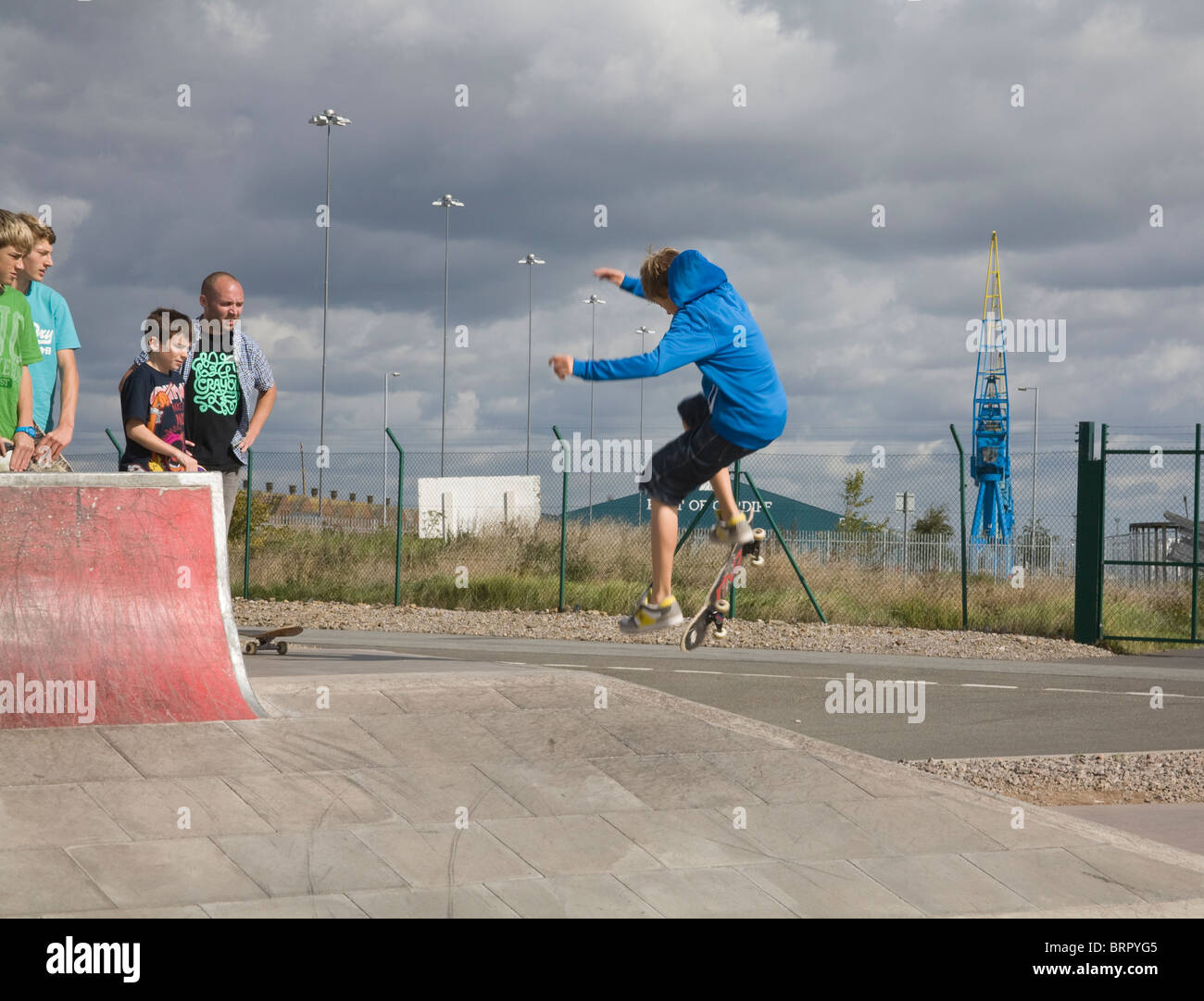 Glamorgan Galles del Sud Gruppo di skate boarder guardando un giovane ragazzo di eseguire un salto Foto Stock