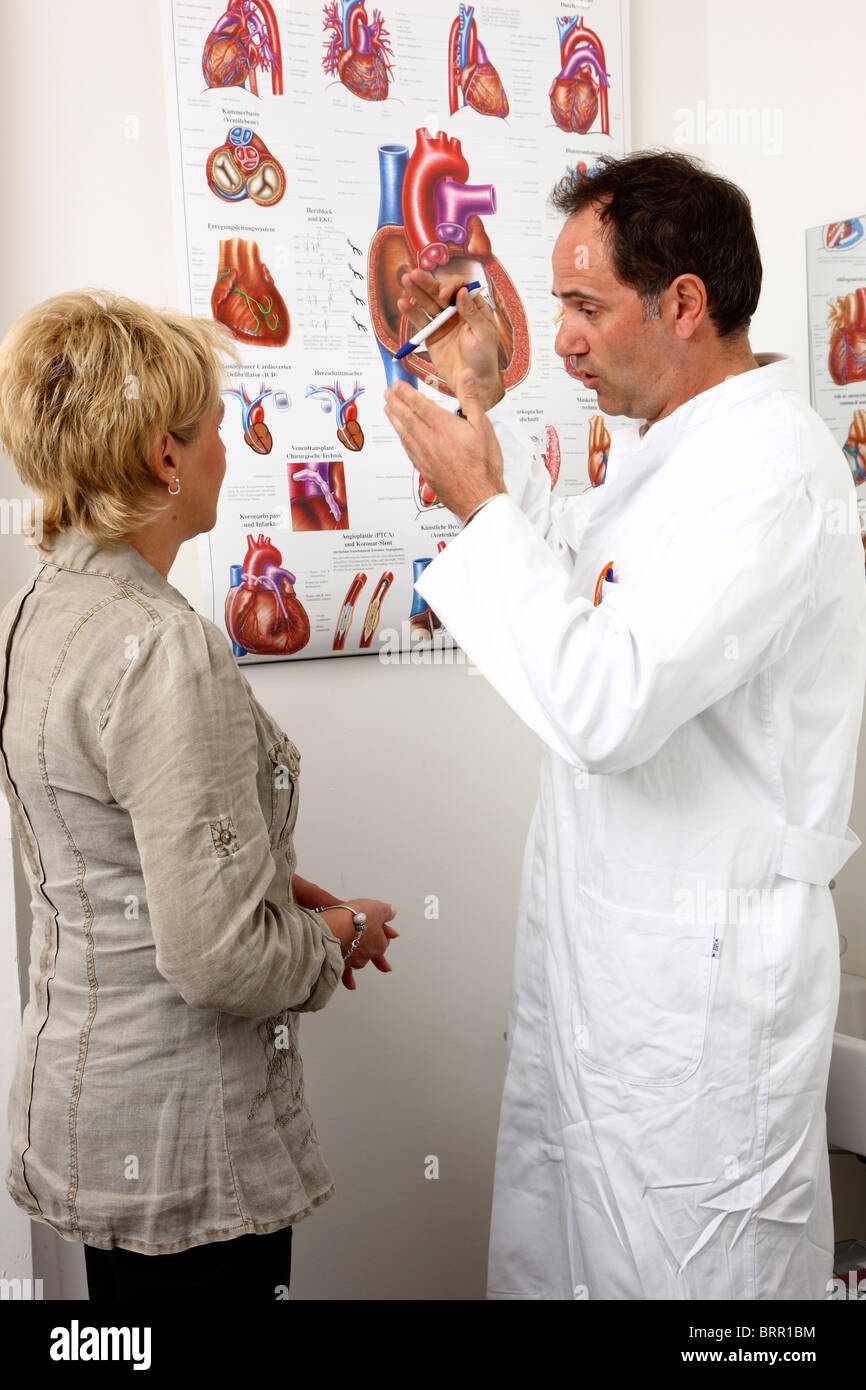 Chirurgia Medici, maschio dottore spiega la funzione e le malattie del cuore umano per un paziente femmina. Foto Stock