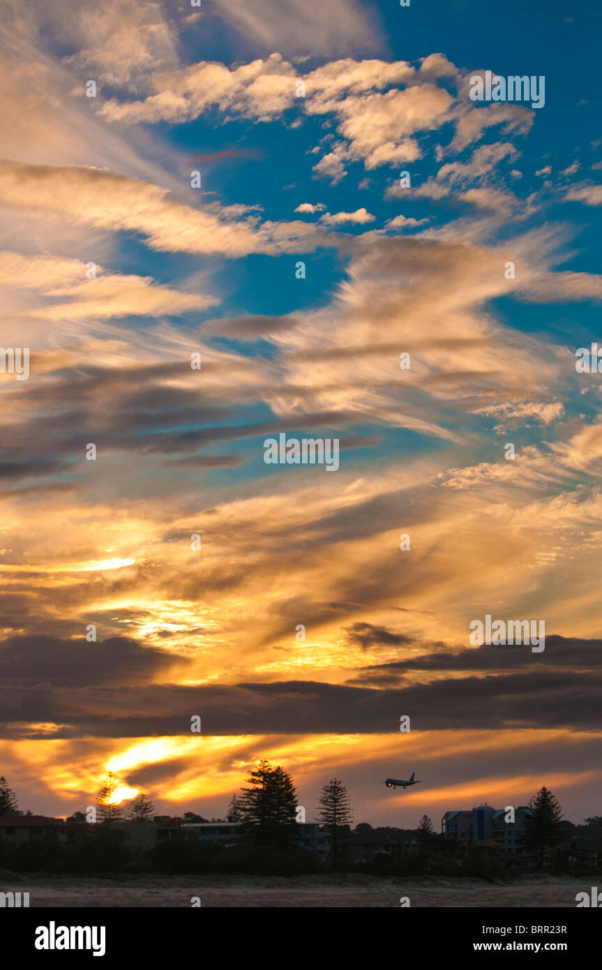 Commerciali di passeggeri di atterraggio a getto sotto wispy nuvole al tramonto, dall'Aeroporto di Gold Coast, Queensland, Australia Foto Stock