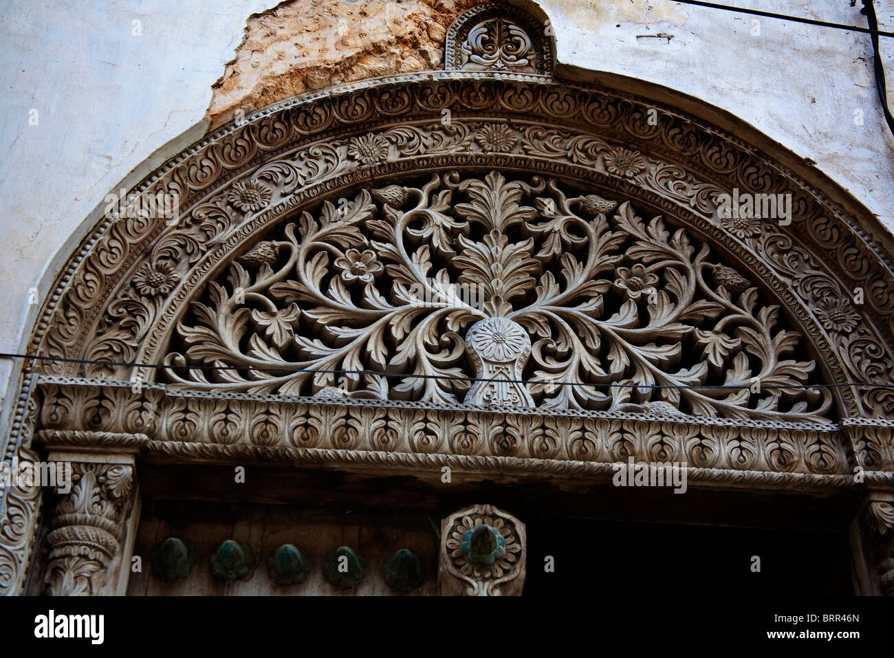 Ornati in legno intagliato arch su una porta Foto Stock