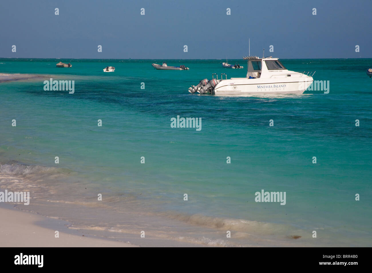 Barca da pesca con due motori fuoribordo ormeggiata in acque poco profonde off Mnemba Island Foto Stock