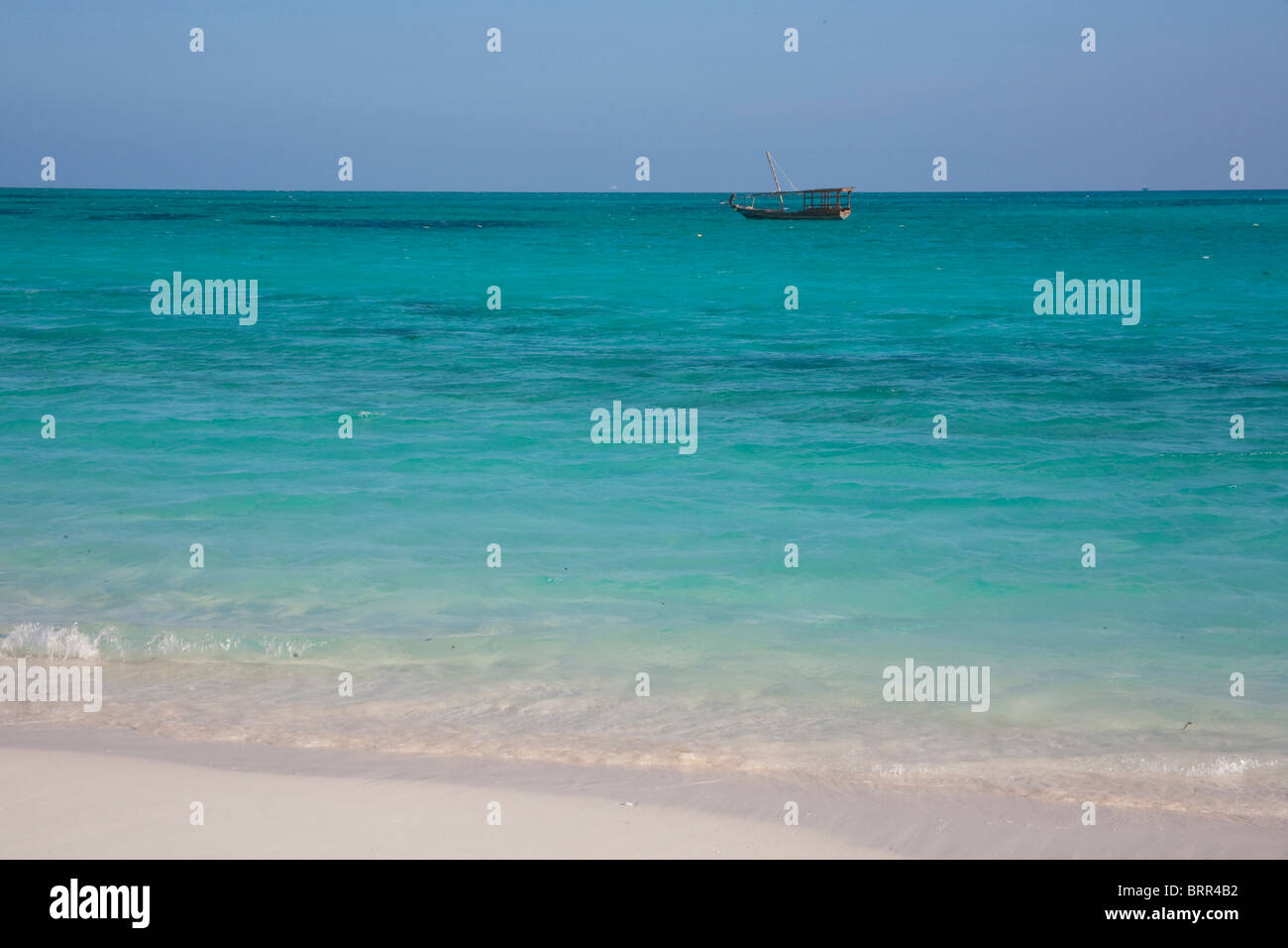 Spiaggia in scena con la barca da pesca in acque tropicali Foto Stock