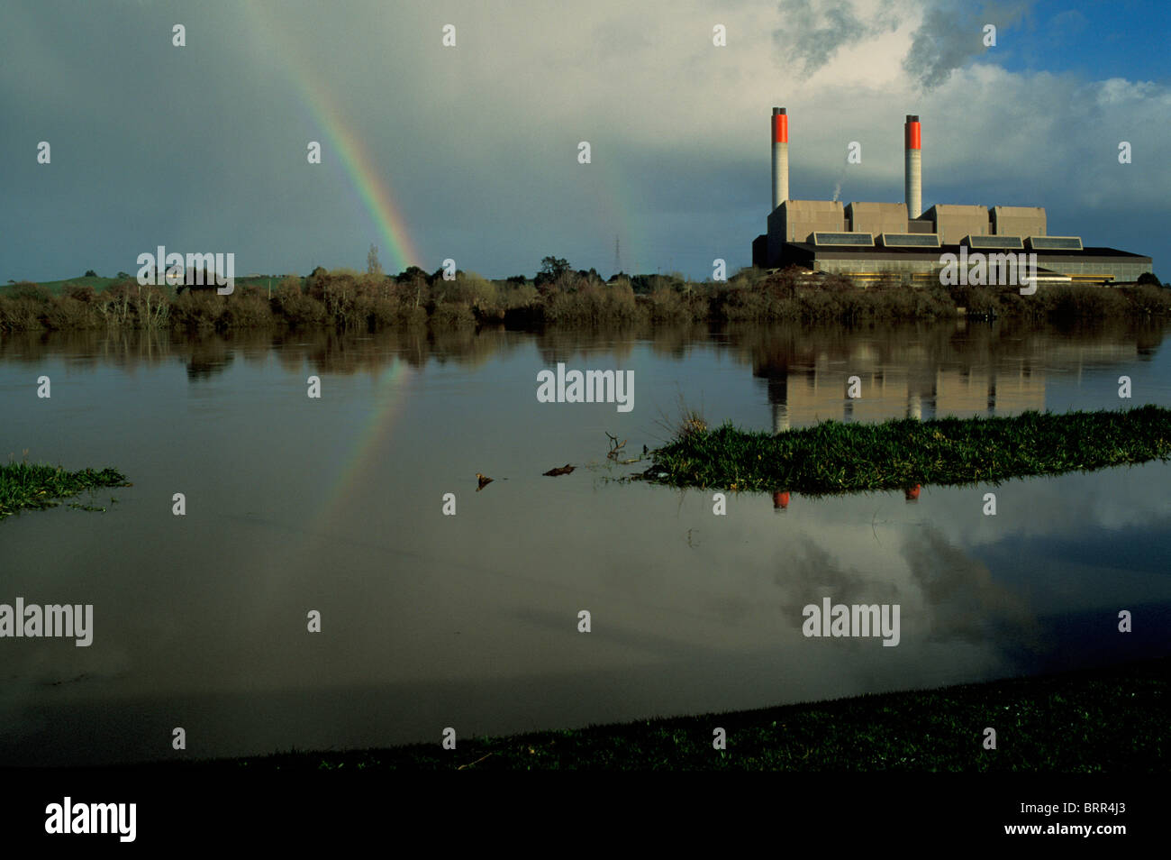 Fiume Waikato e Power Station in prossimità di Huntley con un arcobaleno in background Foto Stock