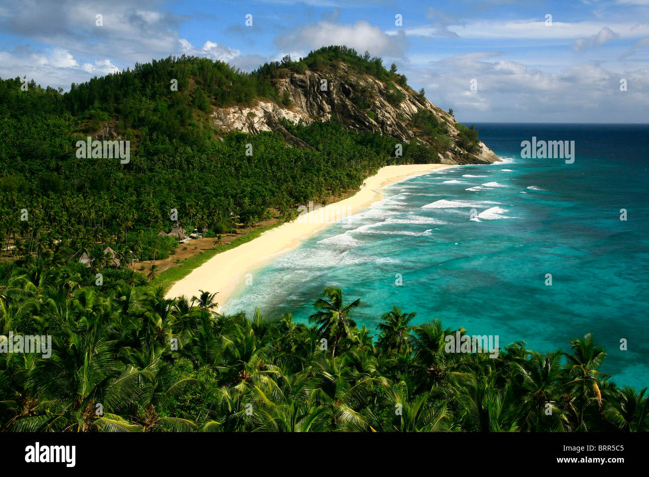 Isola tropicale con fitta vegetazione verde e acqua turchese Foto Stock