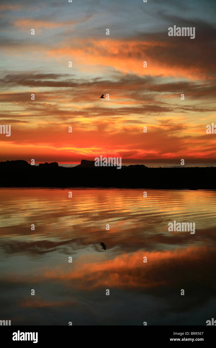 Tramonto e nuvole sopra il punto mare sulla spiaggia Foto Stock
