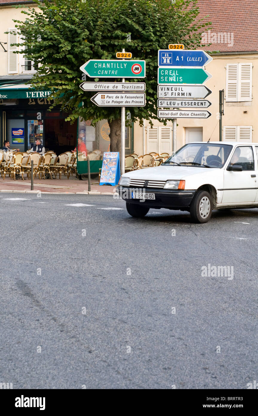 Segni di traffico sulla strada principale che attraversa la città di Chantilly in Francia Foto Stock