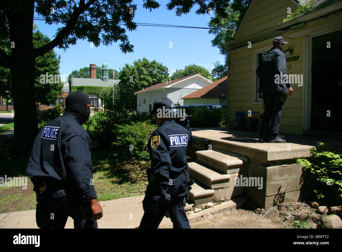 Gli ufficiali di polizia dalla polizia di Detroit unità stupefacenti al di fuori di una casa durante una droga raid. Foto Stock