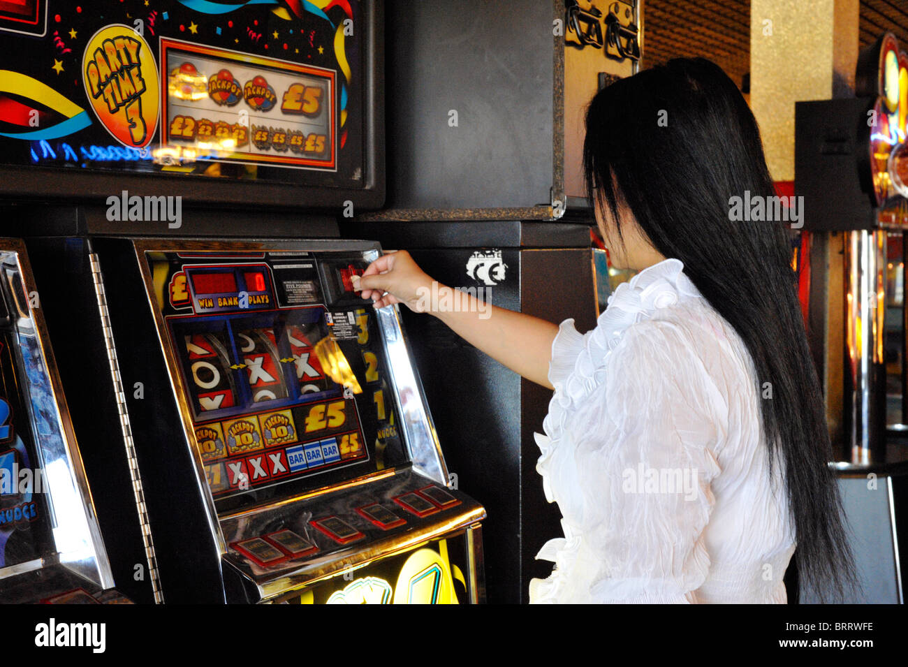 Giovane donna il gioco d'azzardo su slot machine England Regno Unito Foto Stock