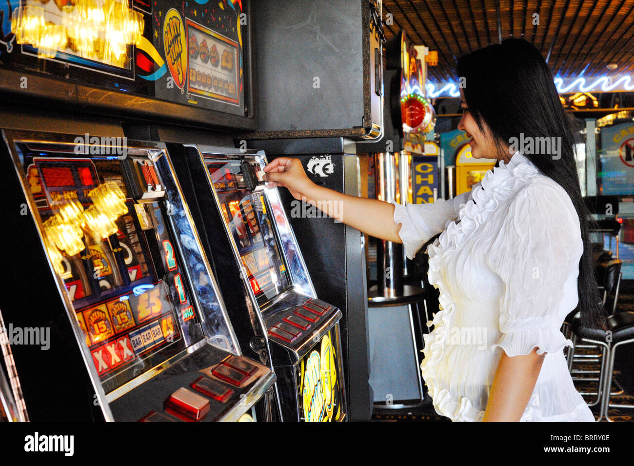 Giovane donna il gioco d'azzardo su slot machine England Regno Unito Foto Stock