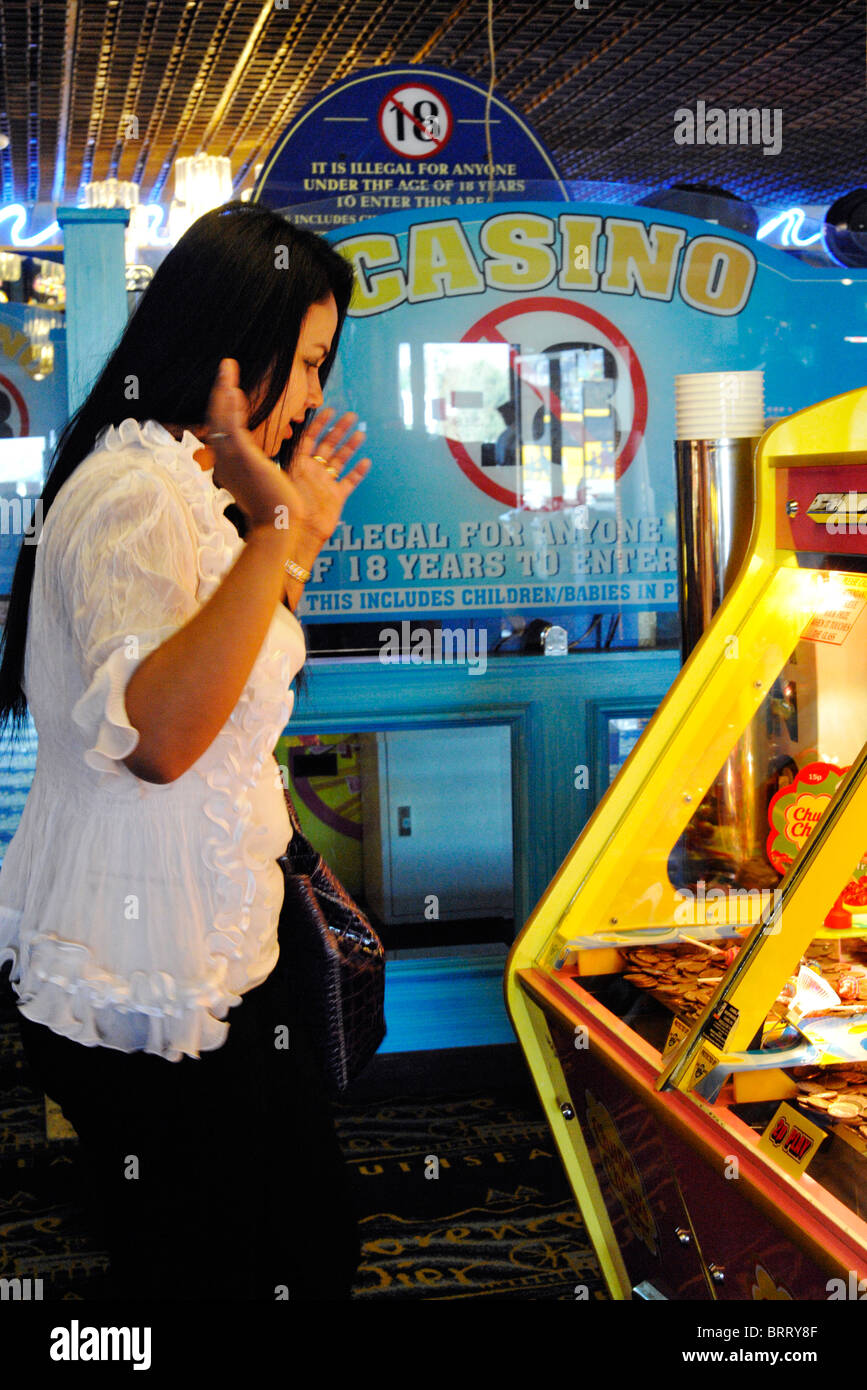 Giovane donna il gioco d'azzardo su slot machine England Regno Unito Foto Stock