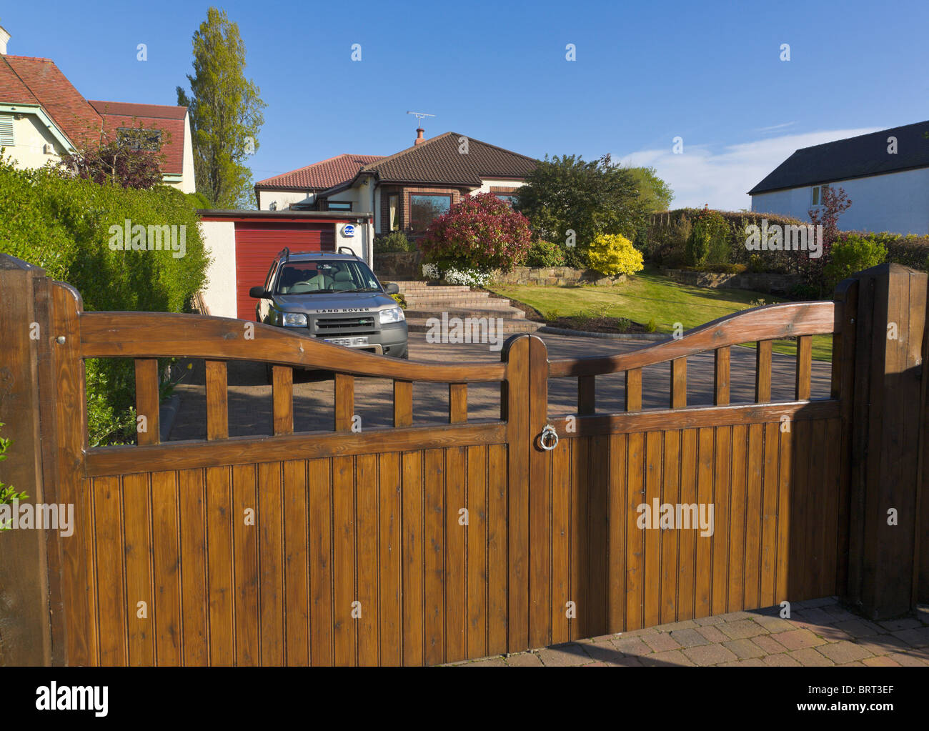 Bungalow giardino anteriore, cancelli e drive con auto parcheggiate, Wirral, Merseyside England Foto Stock