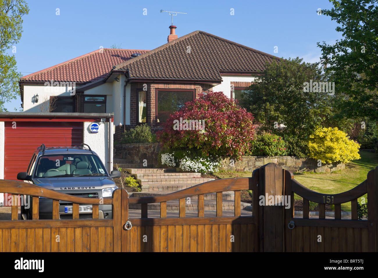 Bungalow giardino anteriore, cancelli e drive con auto parcheggiate, Wirral, Merseyside England Foto Stock