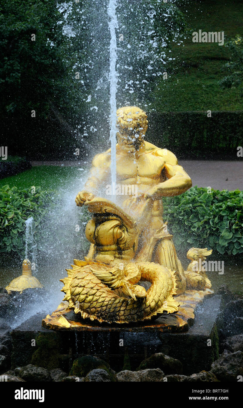 Un gilt statua di bronzo di un tritone di wrestling con un pesce. Questa è parte della grande cascata a Peterhof. San Pietroburgo, Foto Stock