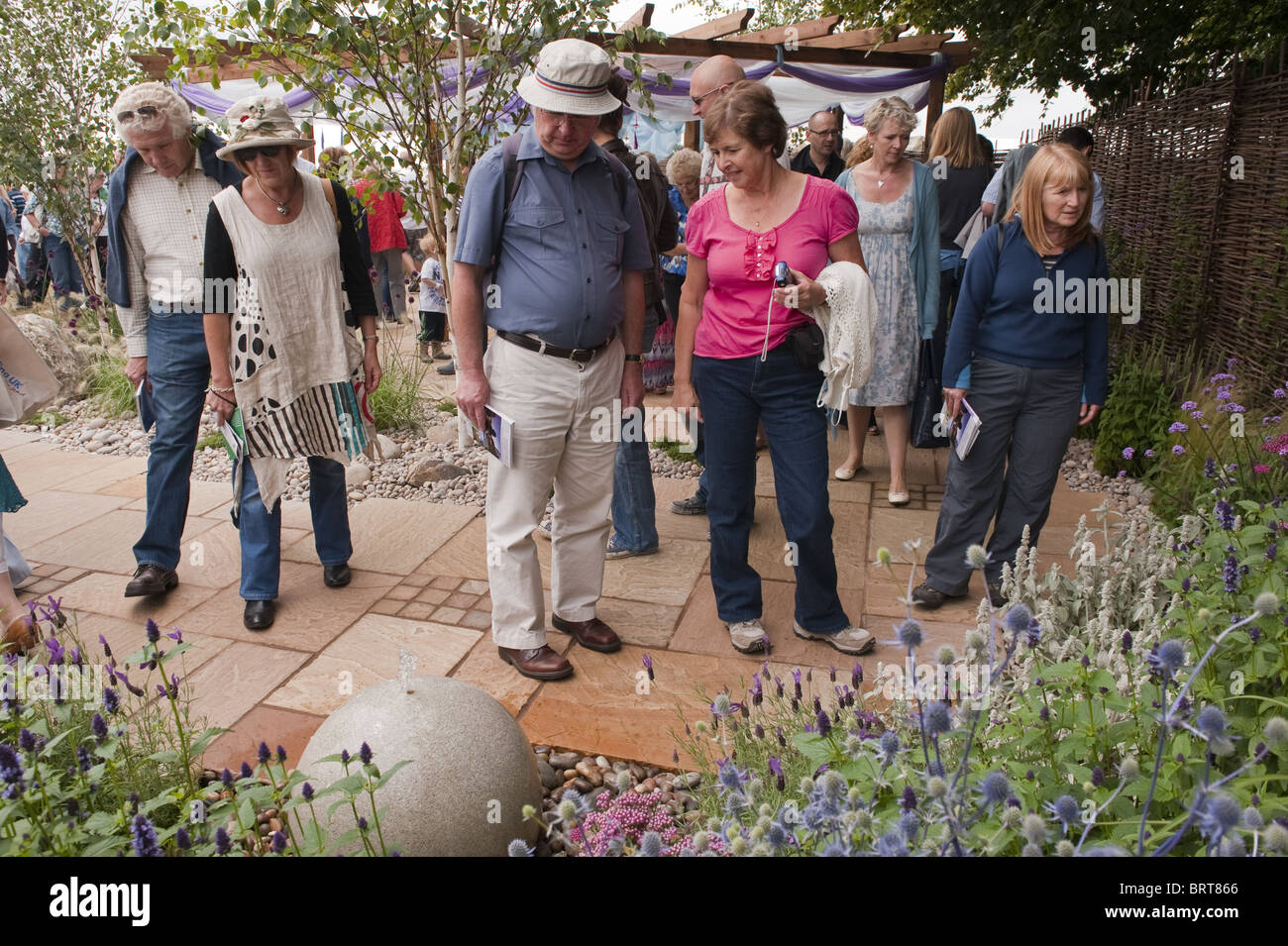 Materiali naturali contemporanei e bordo di fiori dai colori vivaci - giardino con spettacolo "Dreams Just Dreams", RHS Flower Show, Tatton Park, Inghilterra, Regno Unito. Foto Stock