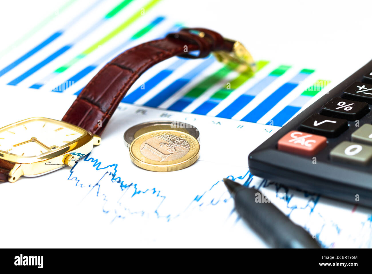 La stampa di grafici finanziari con una calcolatrice, penna e un orologio. Foto Stock