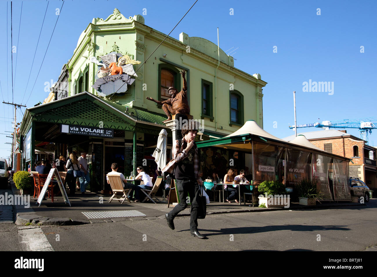 Melbourne street scene con persone presso il cafe. Australia arts Brunswick Street The Entertainer scultura. Foto Stock