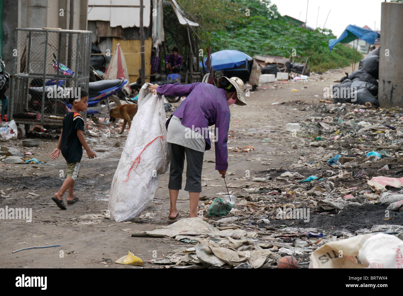 Cambogia Soun Thouch Srey (42) e suo figlio Khoeun Sovan (8) passeggiate in discarica per la ricerca di materiali riciclabili Foto Stock