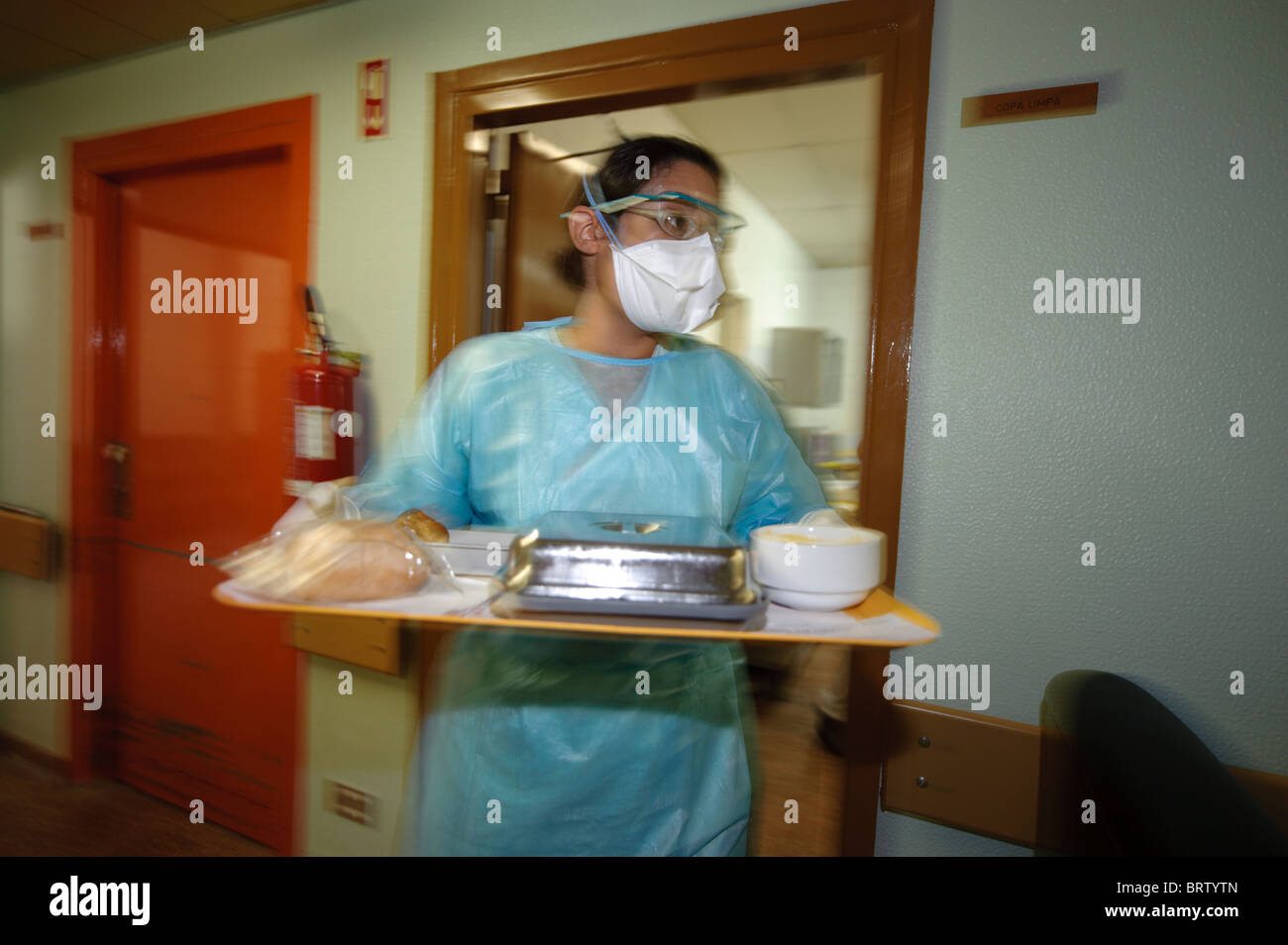 L'operatore sanitario con maschera protettiva trasporta un vassoio con i pasti per i pazienti in un ospedale - coronavirus corona virus Foto Stock